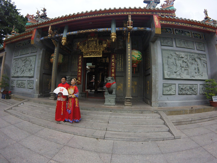 a couple in front of a pagoda in vietnam