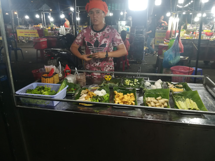 a guy with a funny hat in son tra market vietnam