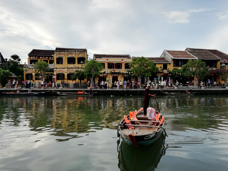 a boat travelling through the river in hoi an