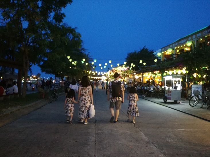 a family dressing funny walking around the night market in hoi an