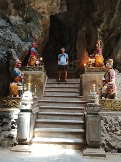 stairs in a cave in marble mountains with buda monuments on each side