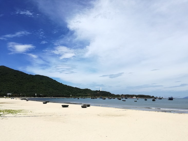 da nang beach with no people around because of the temperature, you could see some boats on the coast