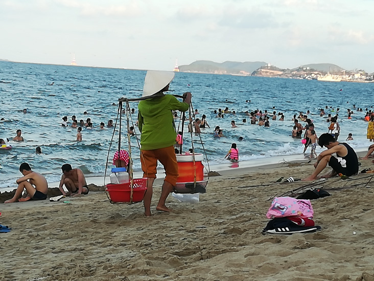 a seller walking in the beach in nha trang vietnam