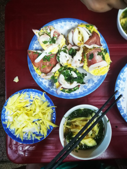 Banh Can made with squid, a side papaya and a sauce