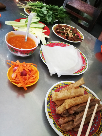 a dish of Nem Nuong in a restaurante in nha trang, a side vegetables and sause